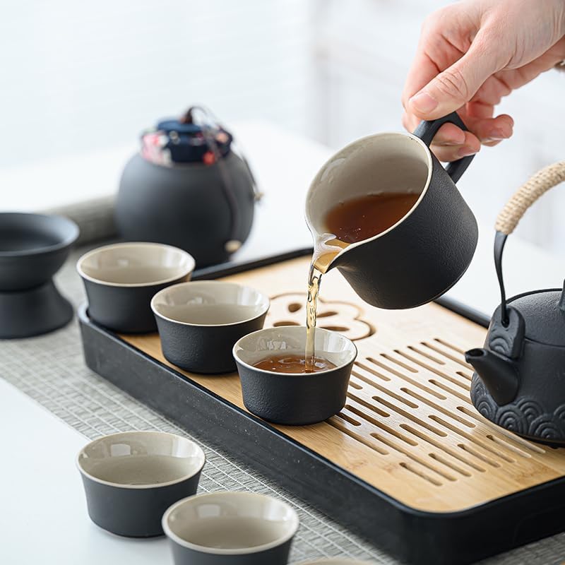 Hands pouring tea from a matte gray ceramic teapot